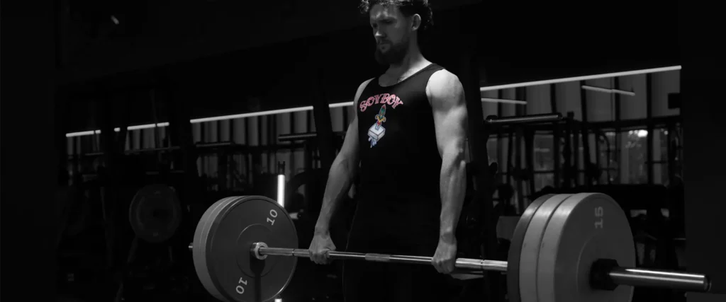 man in a plantbeast gym vest with soyboy text and a tattoo style knife through a block of tofu on it